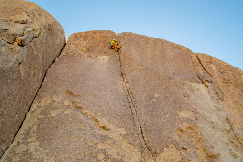 A photo of Jesse climbing a thin crack called the Bird of Fire.